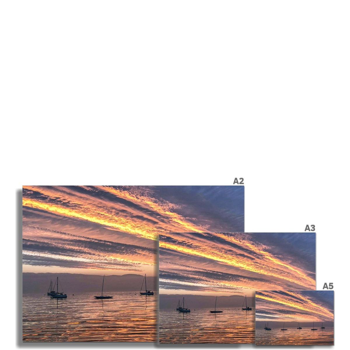 Fiery sunset fine art print of sailboats on calm water under vibrant orange and golden sky at sunset