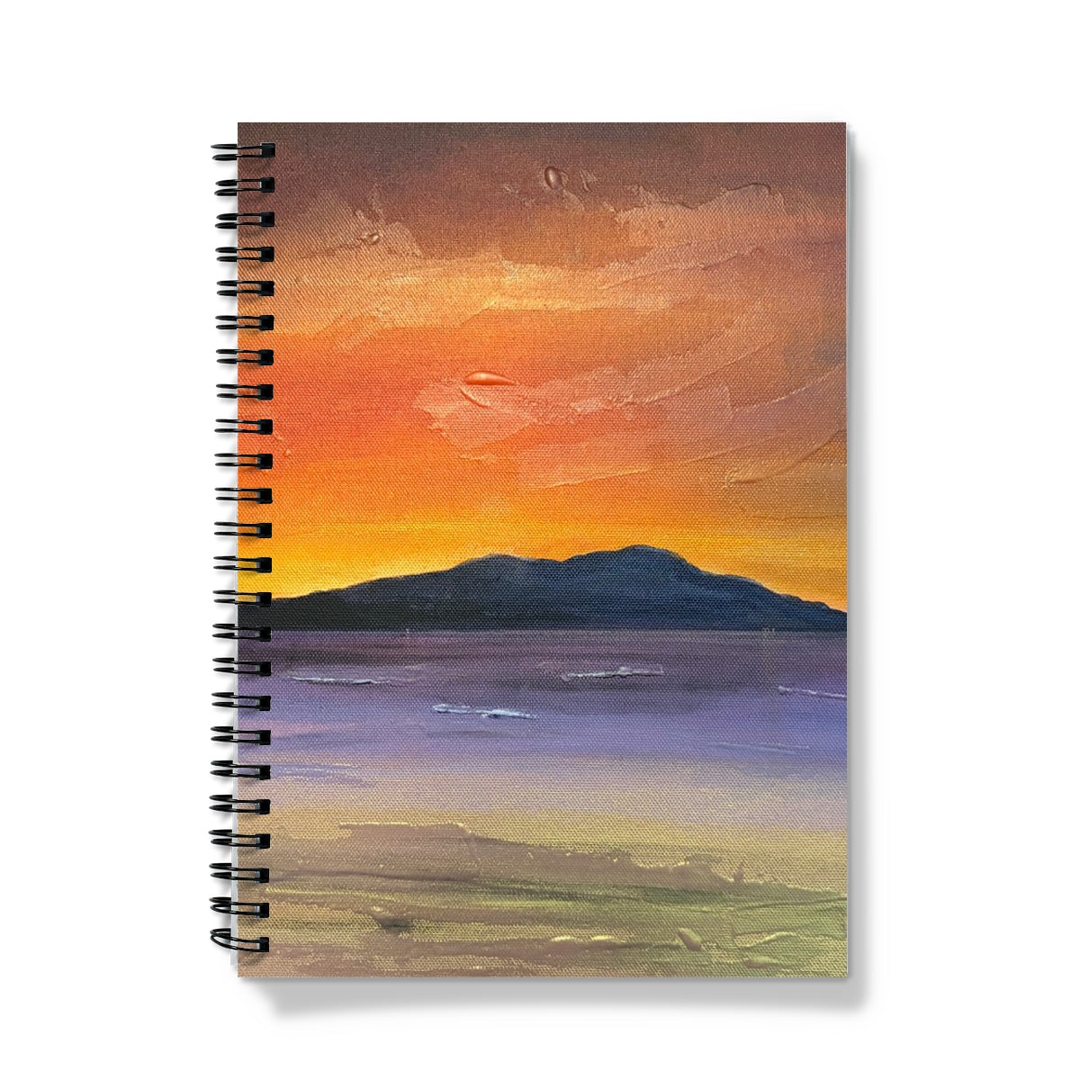 A spiral-bound Arran Embers notebook with a vibrant orange and purple sunset painting over dark mountains