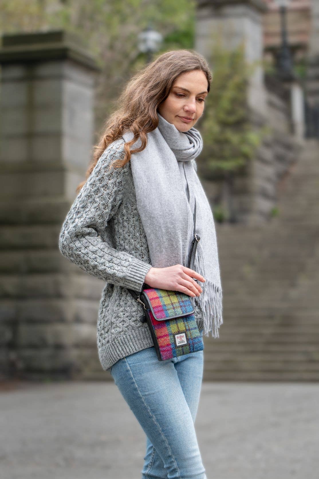 A vibrant blue and pink check harris tweed mini crossbody bag made of woven wool with a small brand tag on front