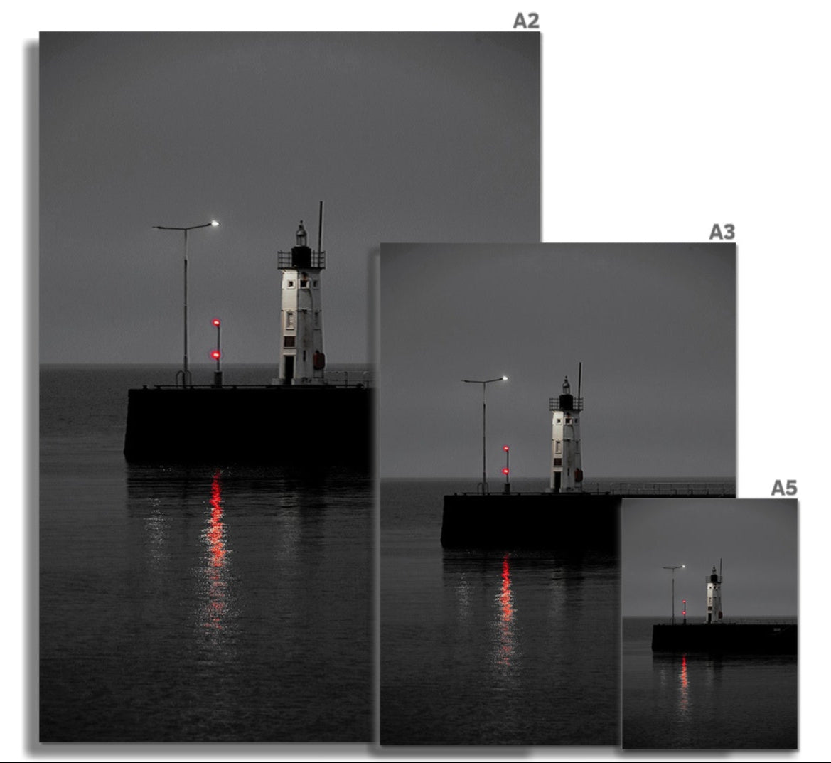 Anstruther Lighthouse red fine art print showing a black and white lighthouse with glowing red lights reflecting on water