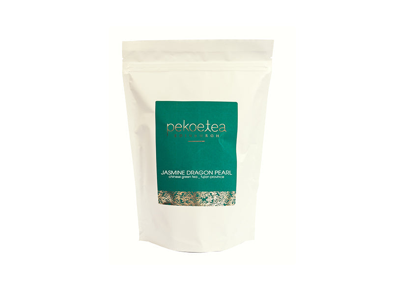A white resealable pouch of jasmine dragon pearl chinese green tea with a teal label and gold text