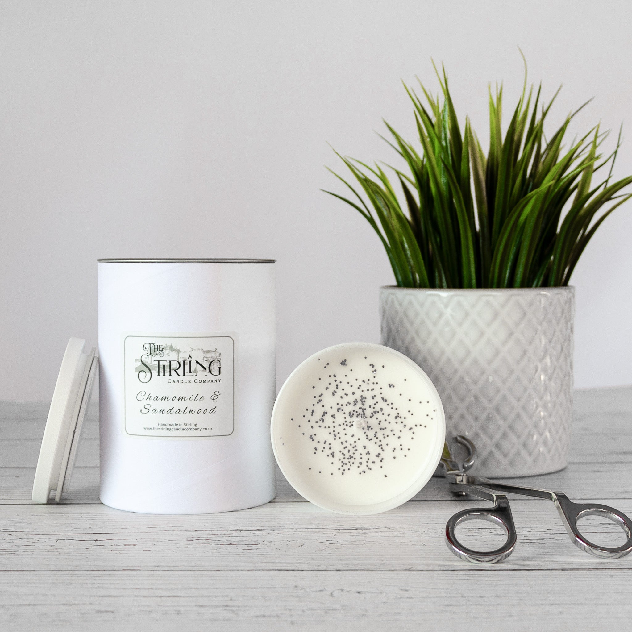 White cylindrical chamomile and sandalwood scented candle with silver lid from the string candle company