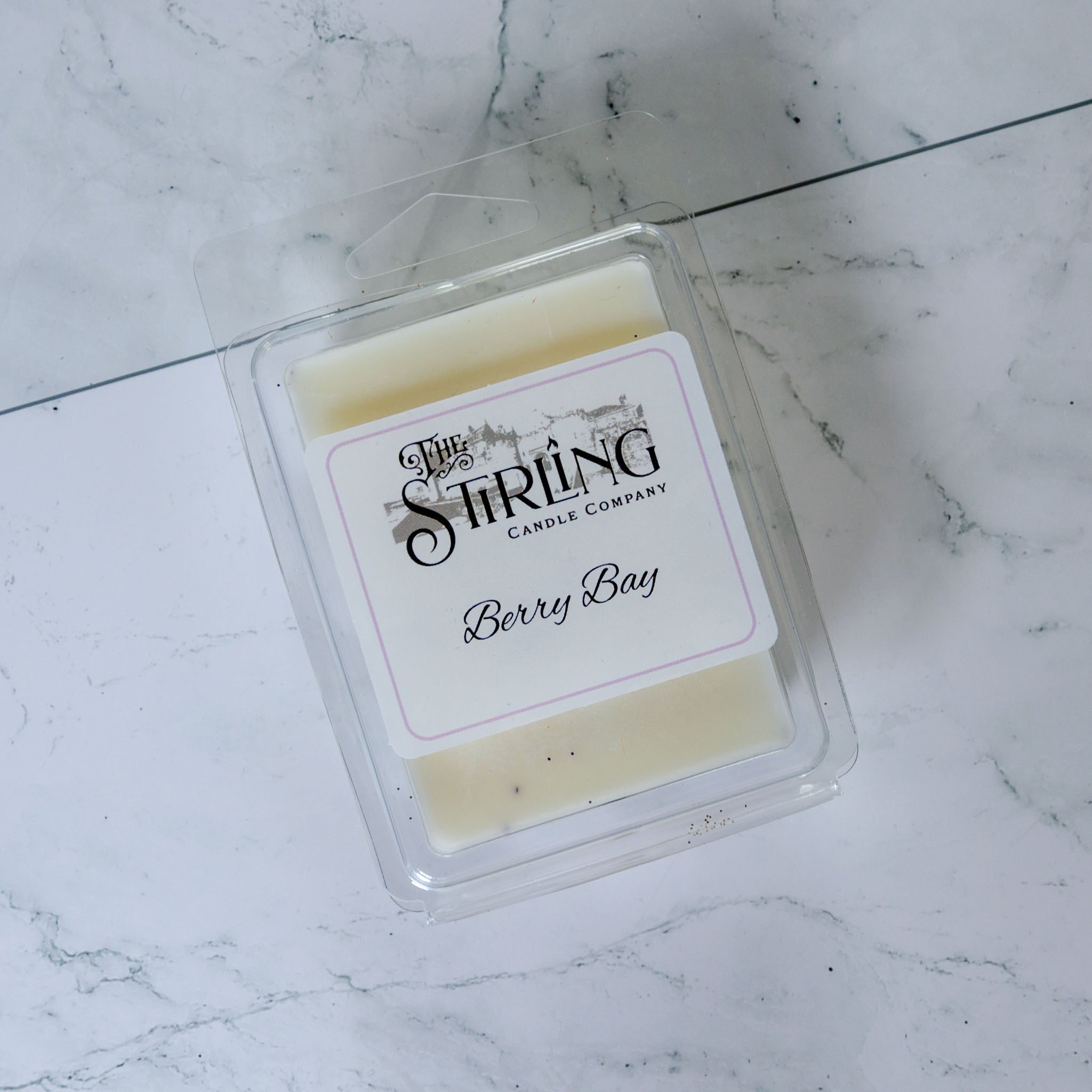 A pale yellow berry bay wax melt clamshell in a clear plastic container by the stirling candle company