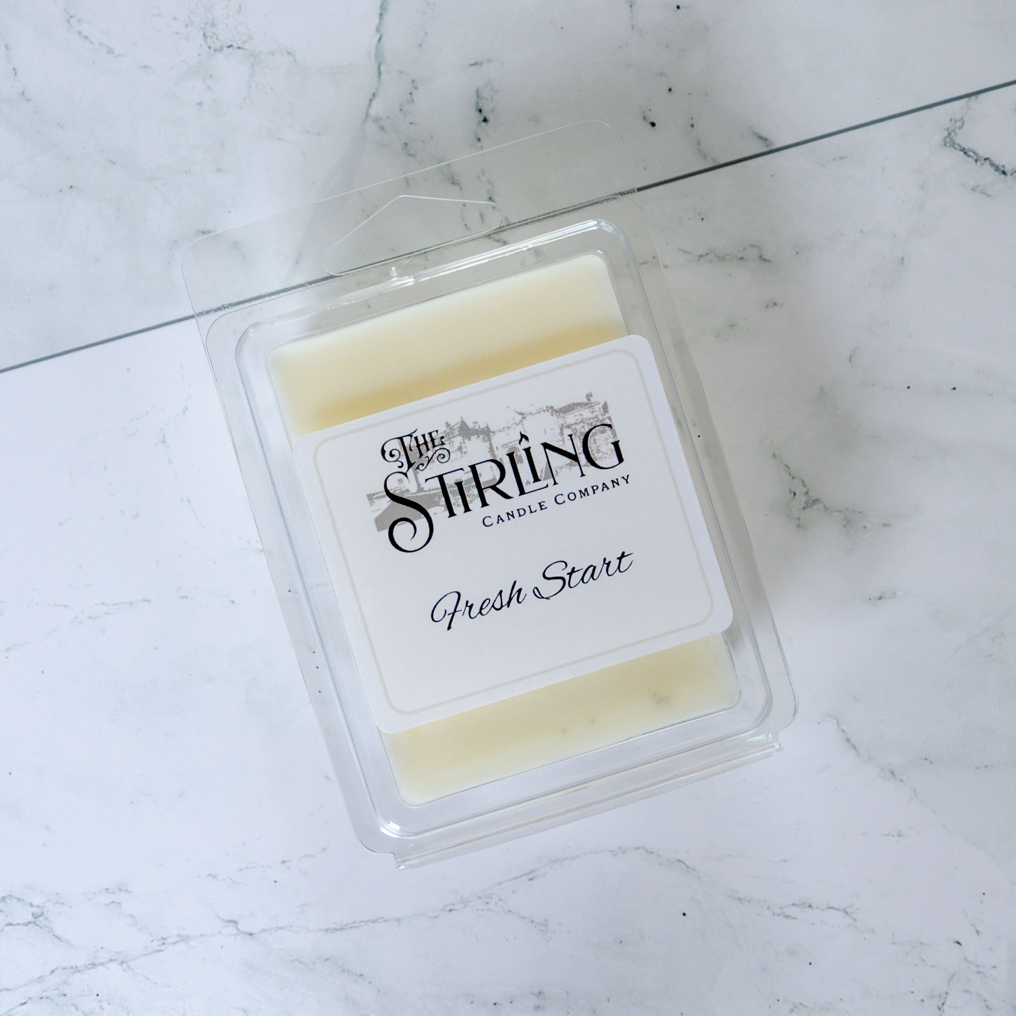 Fresh start wax melt clamshell by the stirling candle company is a pale yellow wax melt in a clear plastic container