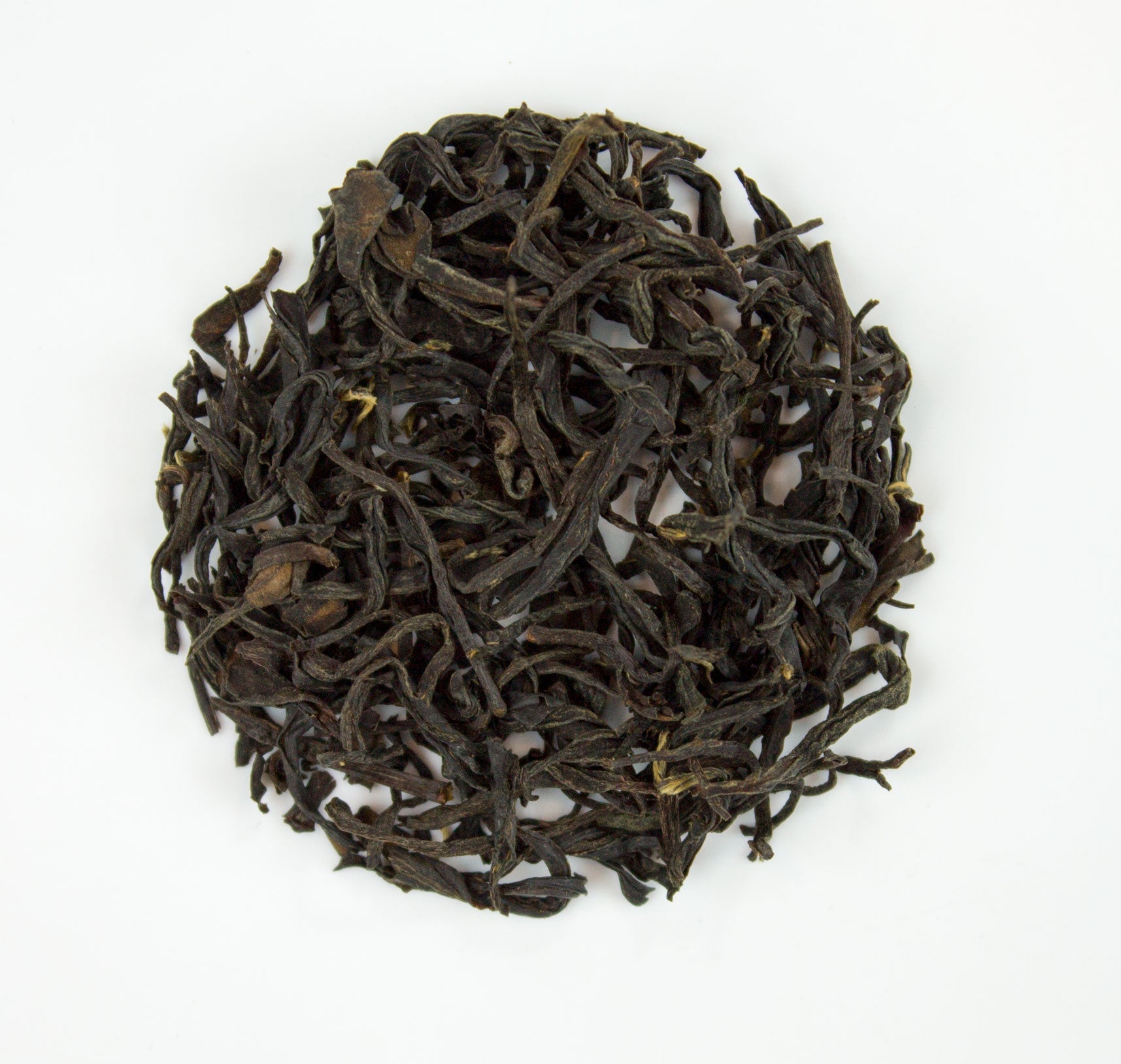 Dark twisted tea leaves with glossy texture and yellow tips in zhou family handmade wuyi wild lapsang souchong