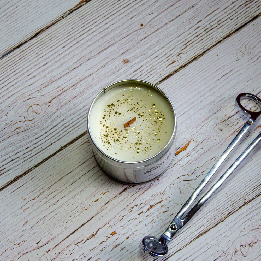 Amber & Spice travel tin candle with creamy white wax, wooden wick, and golden glitter