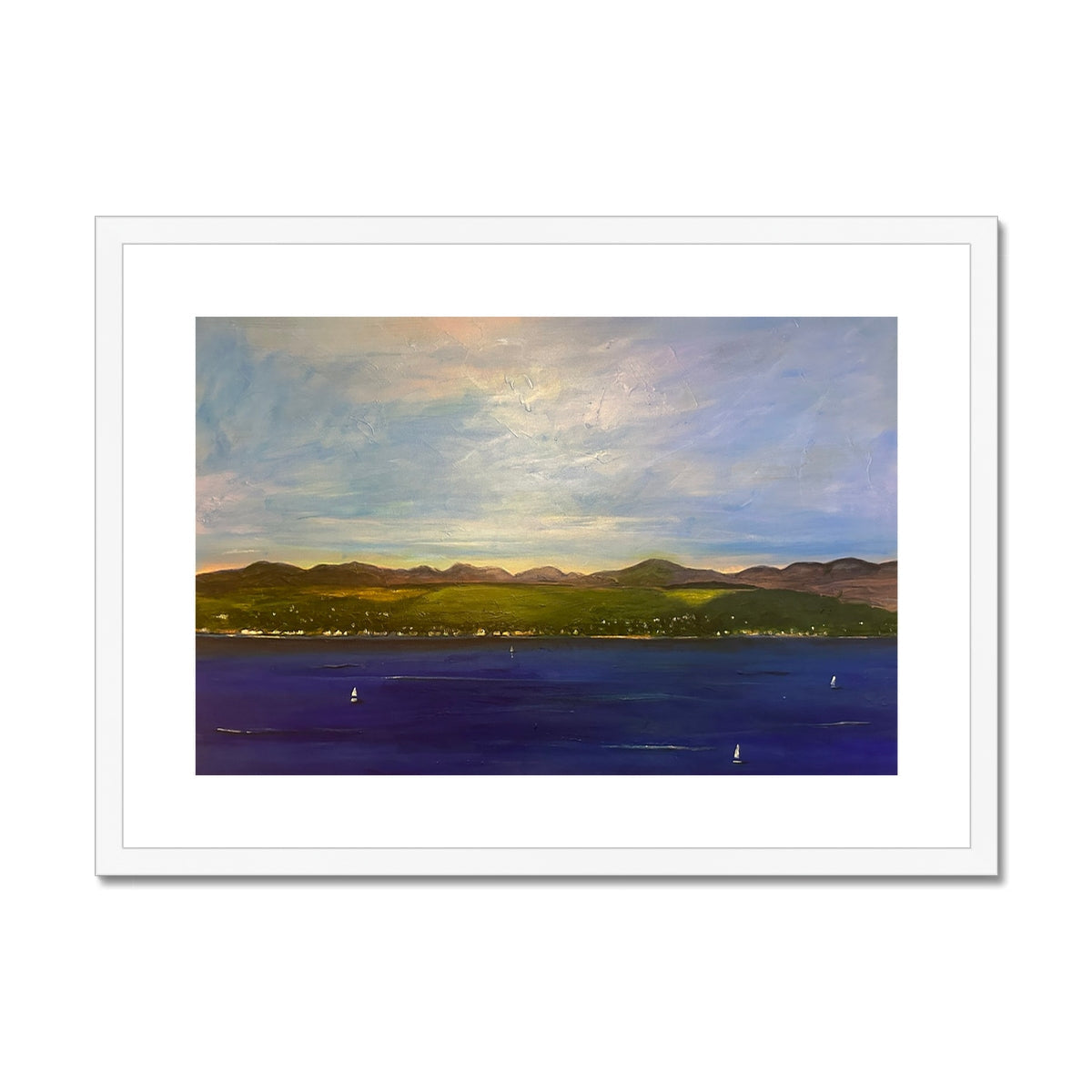Framed landscape painting of a bay with green hills, a town, sailboats, and cloudy sky
