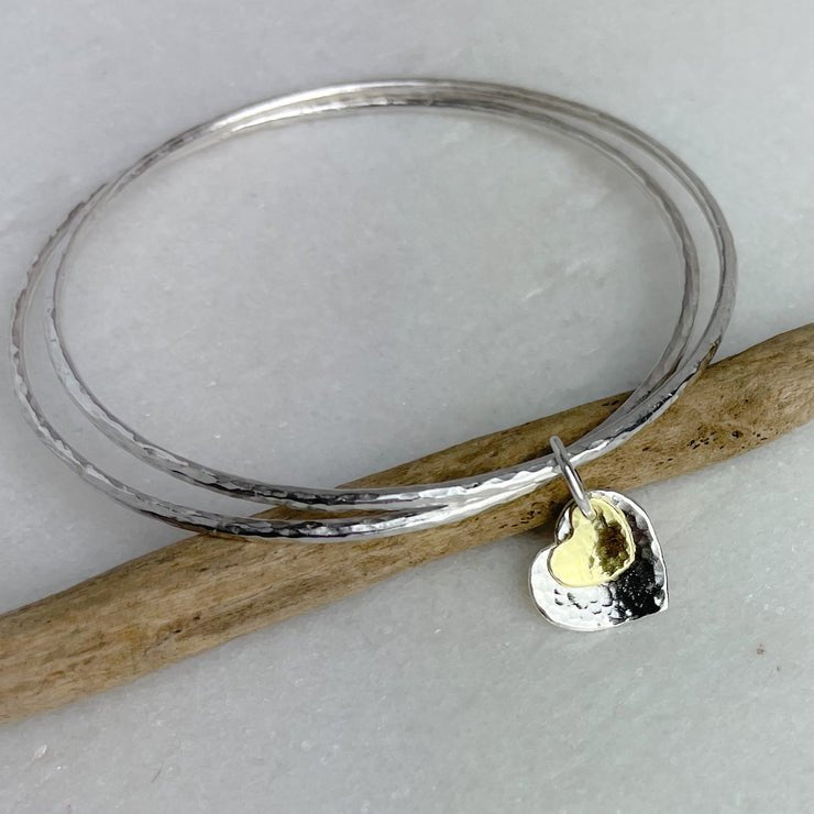 Silver hammered brass bangle with two-tone heart charm by Lindsay Mcdowall Jewellery