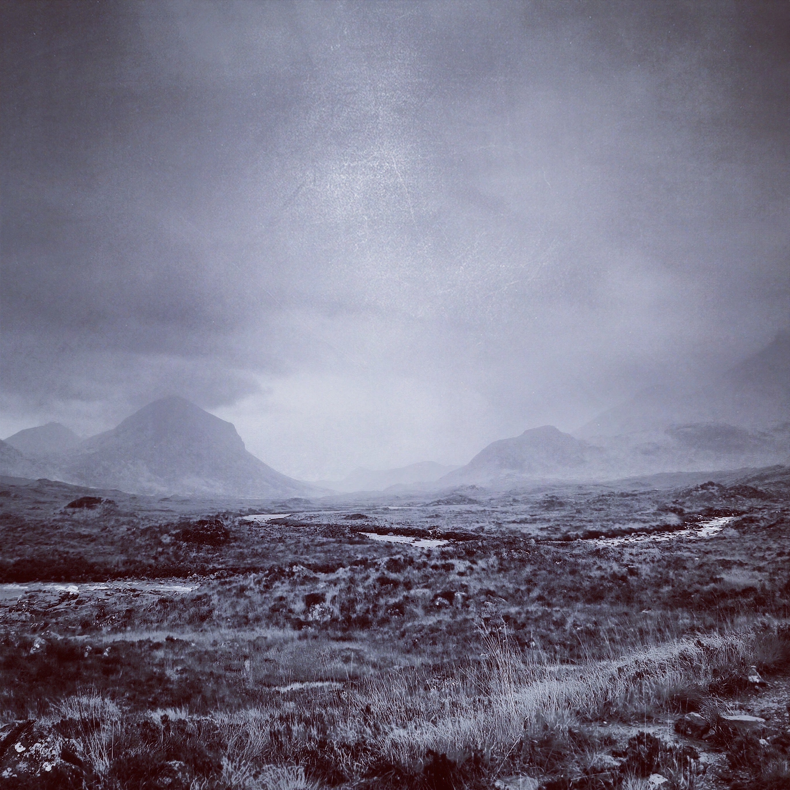 Bleak monochrome landscape with distant misty mountains in The Brooding Cuillin Skye Scotland In Your Pocket