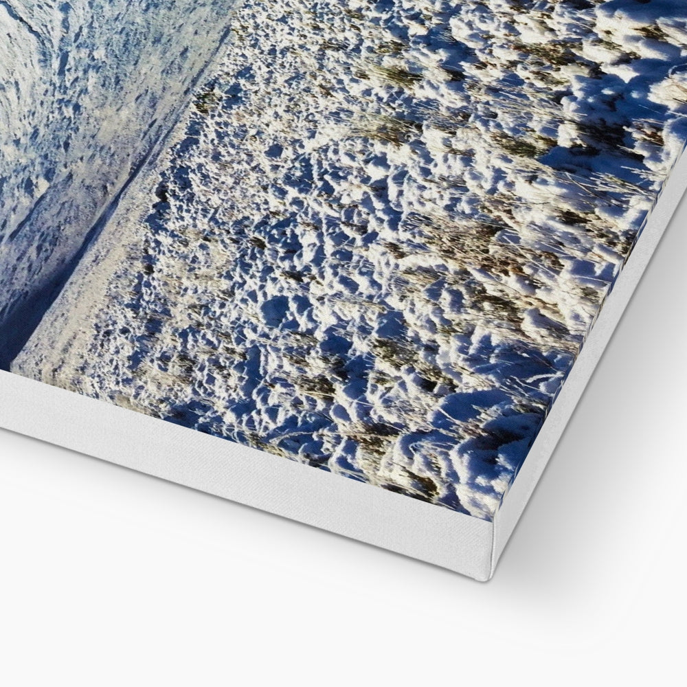 Silver metallic canvas print of snow-covered Buachaille Etive Mor mountain under blue sky