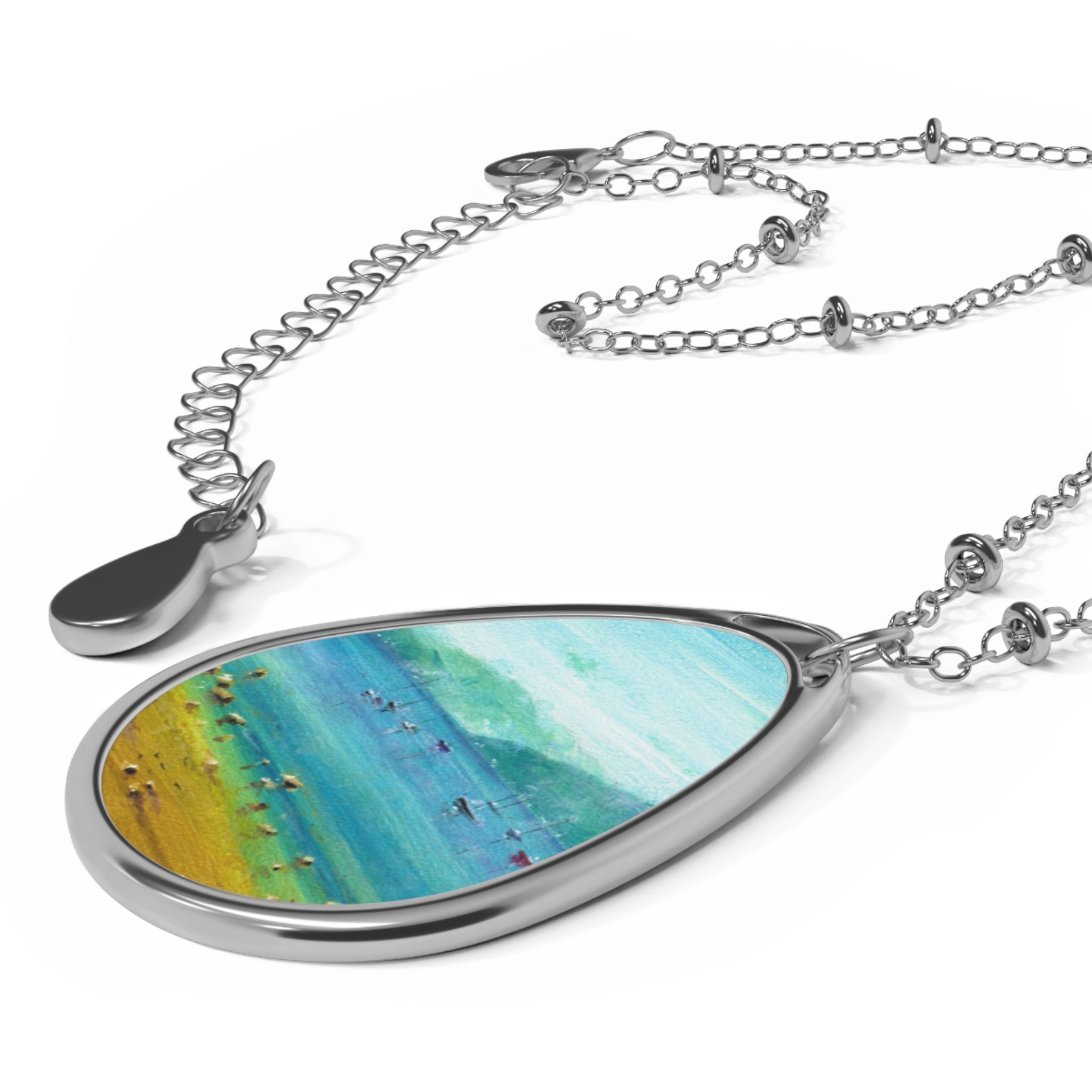 Teardrop silver pendant with abstract blue, green, and yellow design on silver chain