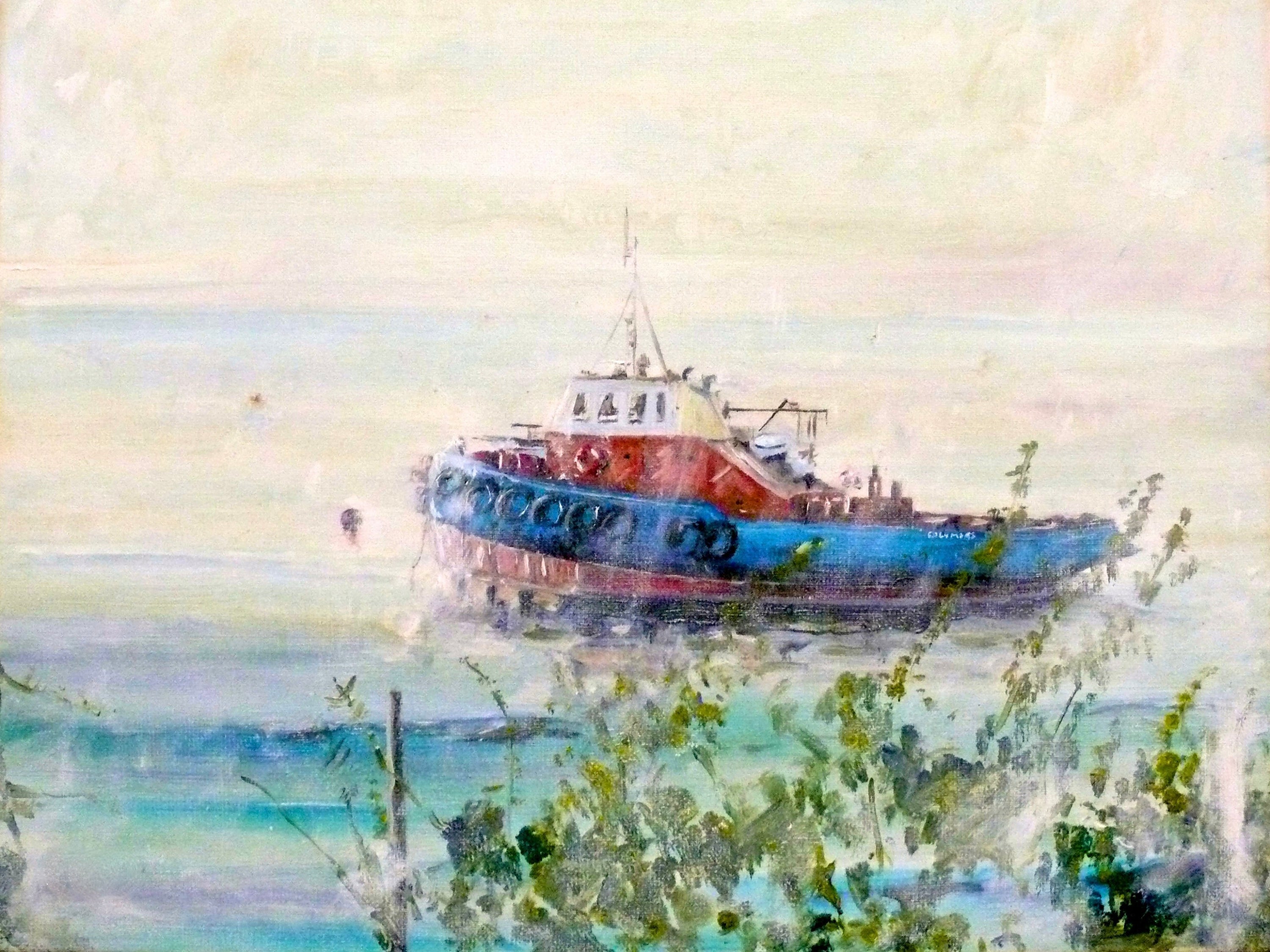 Multicolored tugboat with white, orange, and blue sections and black fenders on Clyde River