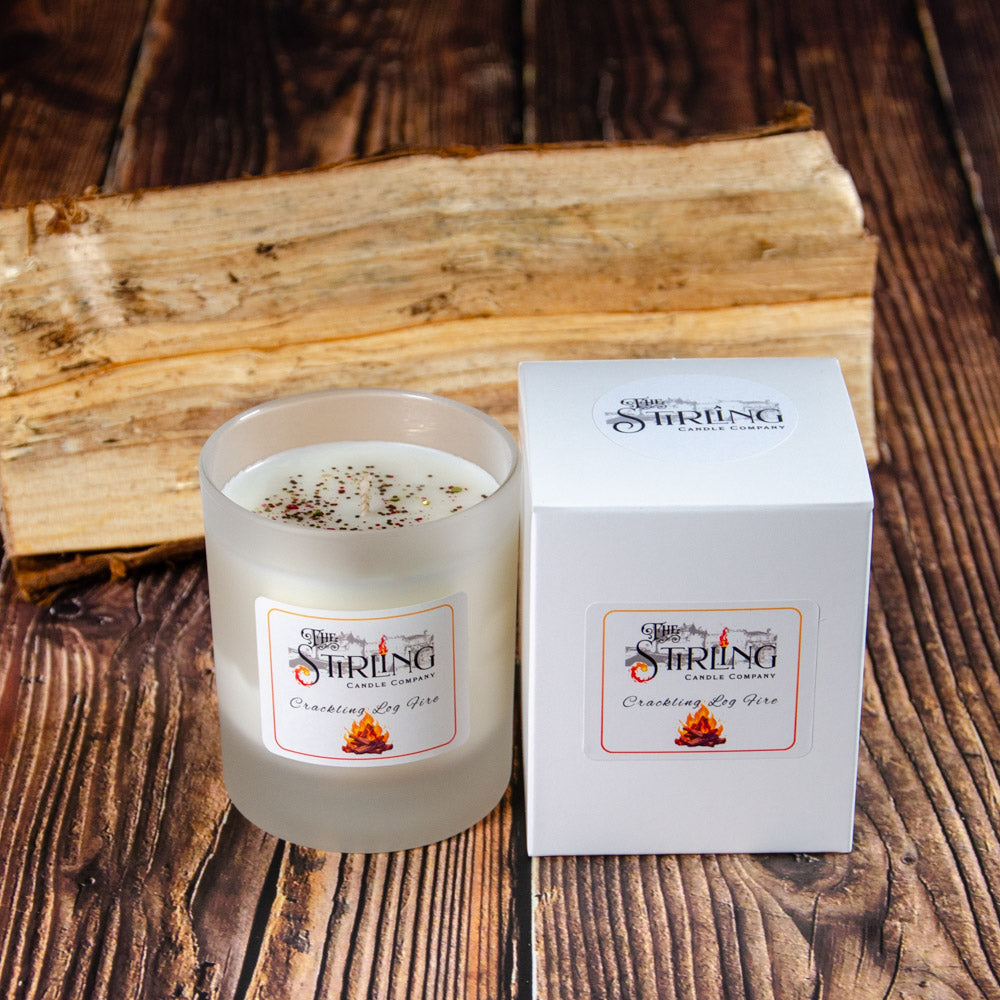Crackling Log Fire medium white frosted glass candle with speckles beside box