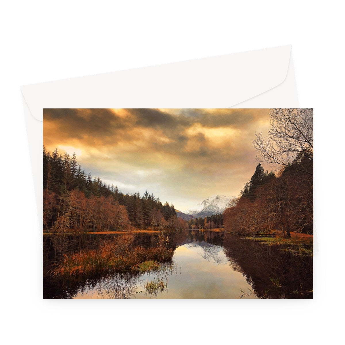 Golden sunset over Glencoe Lochan with reflective water and forest silhouette