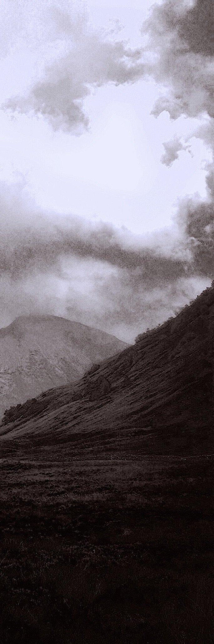 Moody monochrome landscape of misty mountains and dense vegetation from Glencoe Mist Triptych