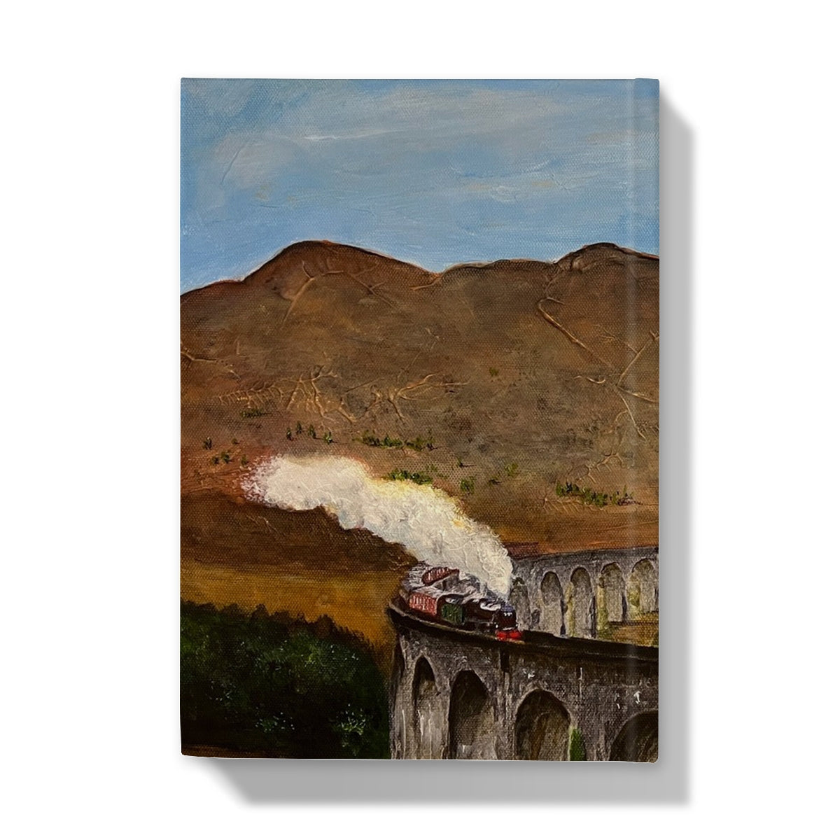 Steam locomotive model train on Glenfinnan Viaduct bridge with smoke