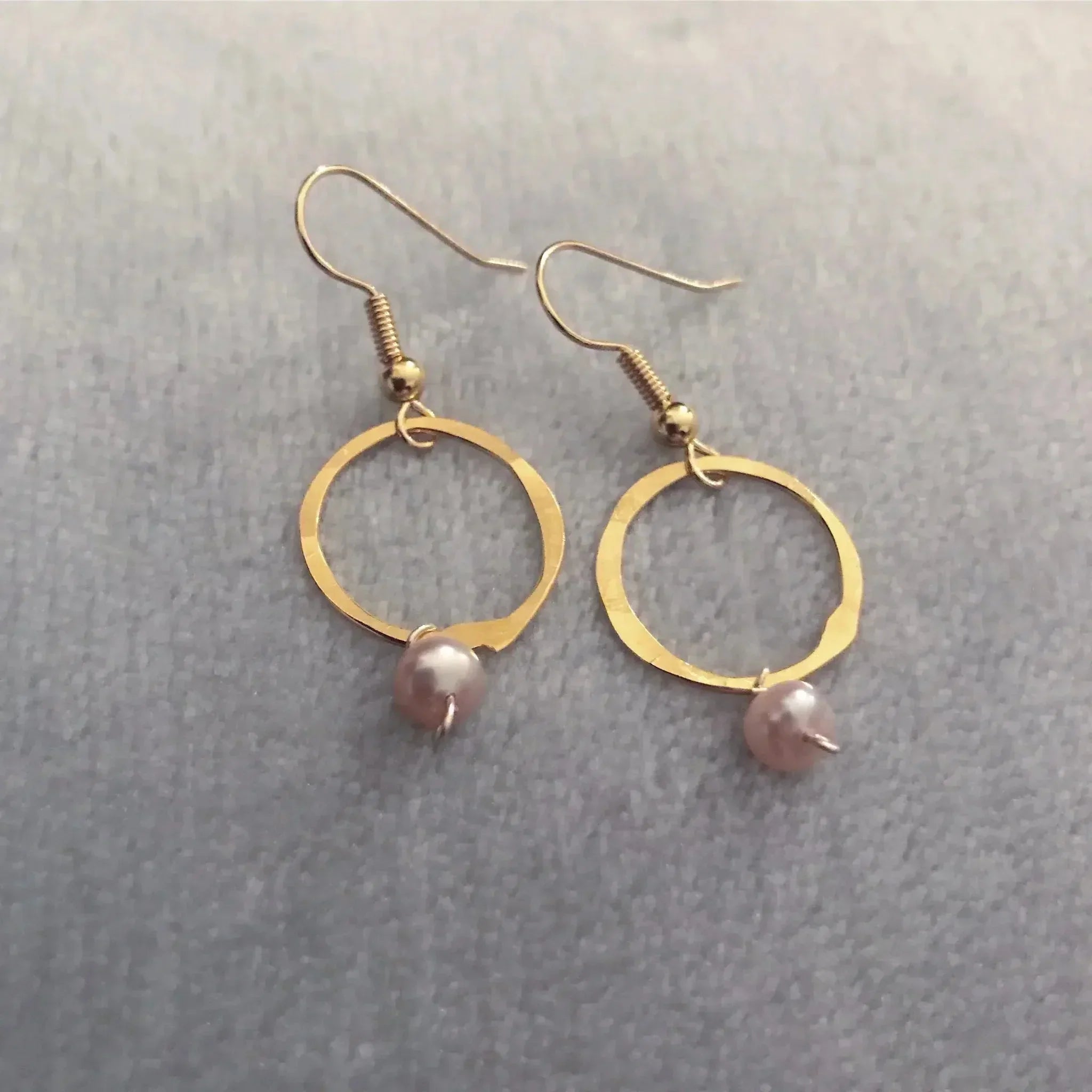 Gold-toned hammered hoop earrings with pink pearl dangles by Genna Miller Jewellery