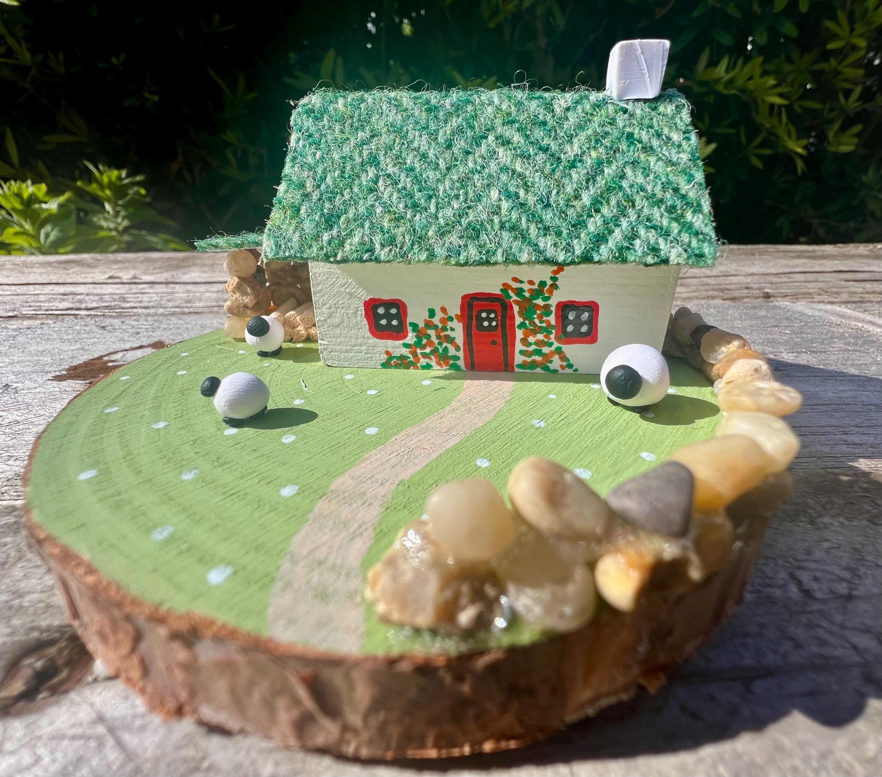 Handcrafted miniature Scottish Bothy with green textured roof, red door, sheep, and grassy scene