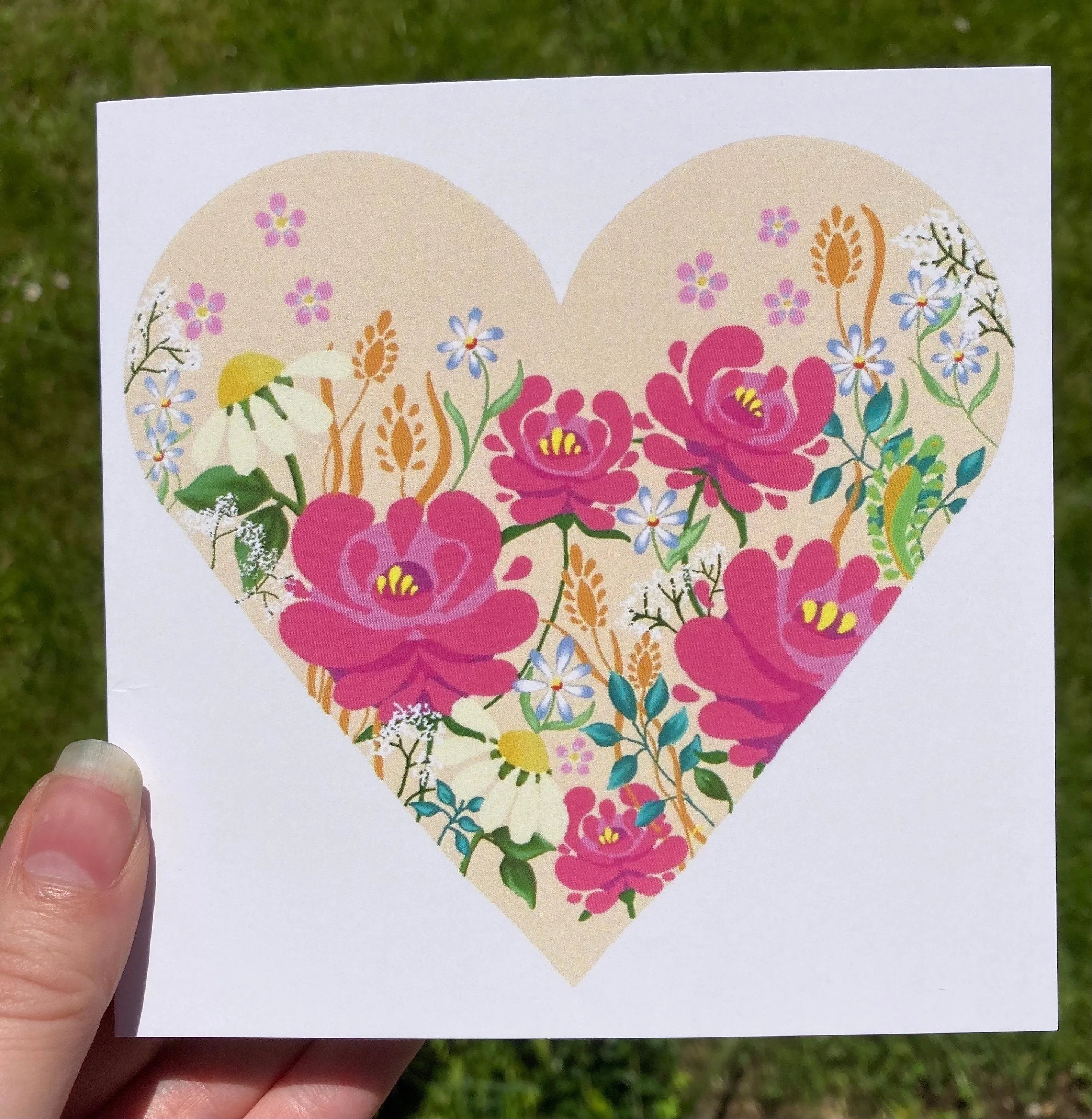White greeting card with a heart-shaped floral illustration of roses and daisies