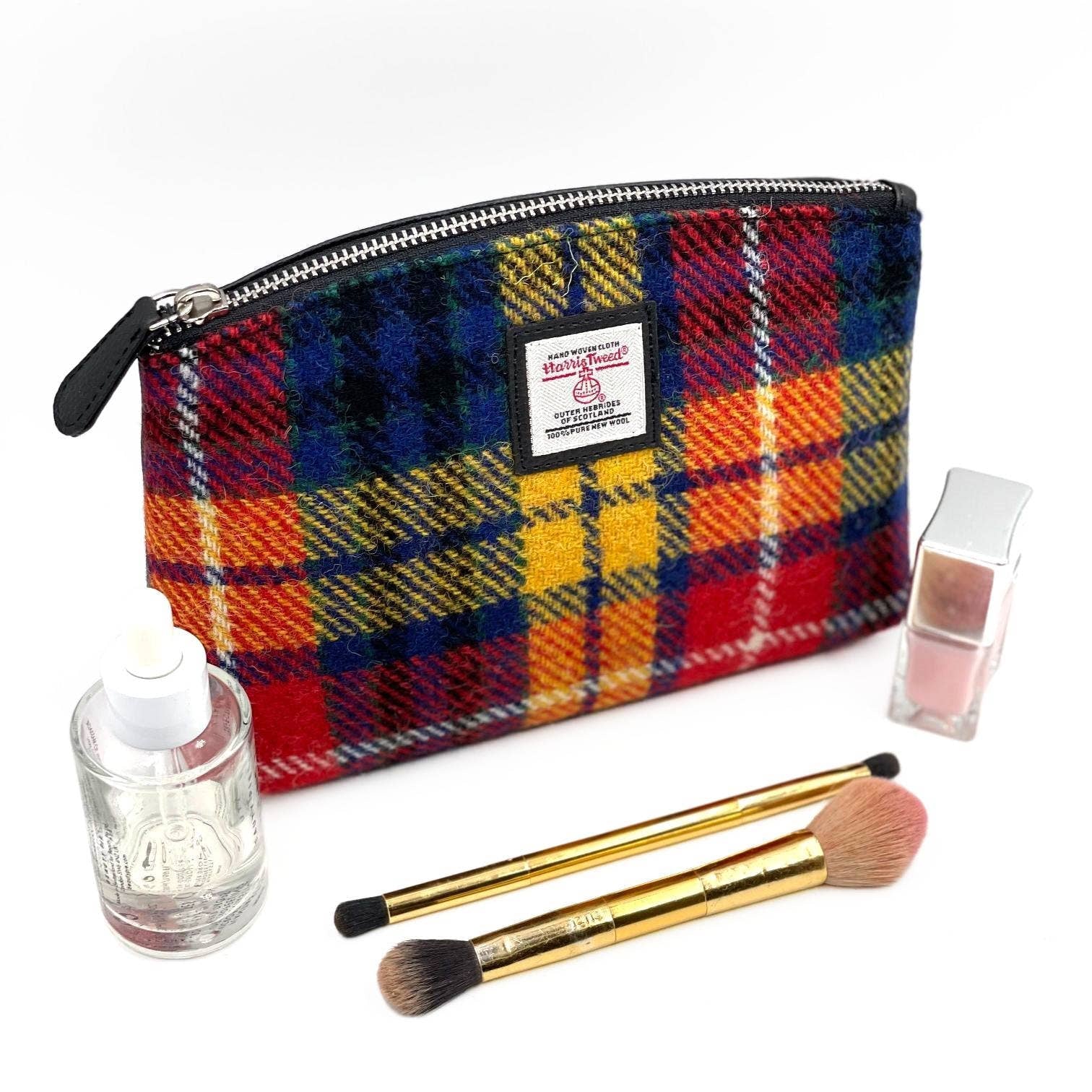 Vibrant saffron Harris Tweed cosmetic bag with multicolored tartan wool, black zipper, and label