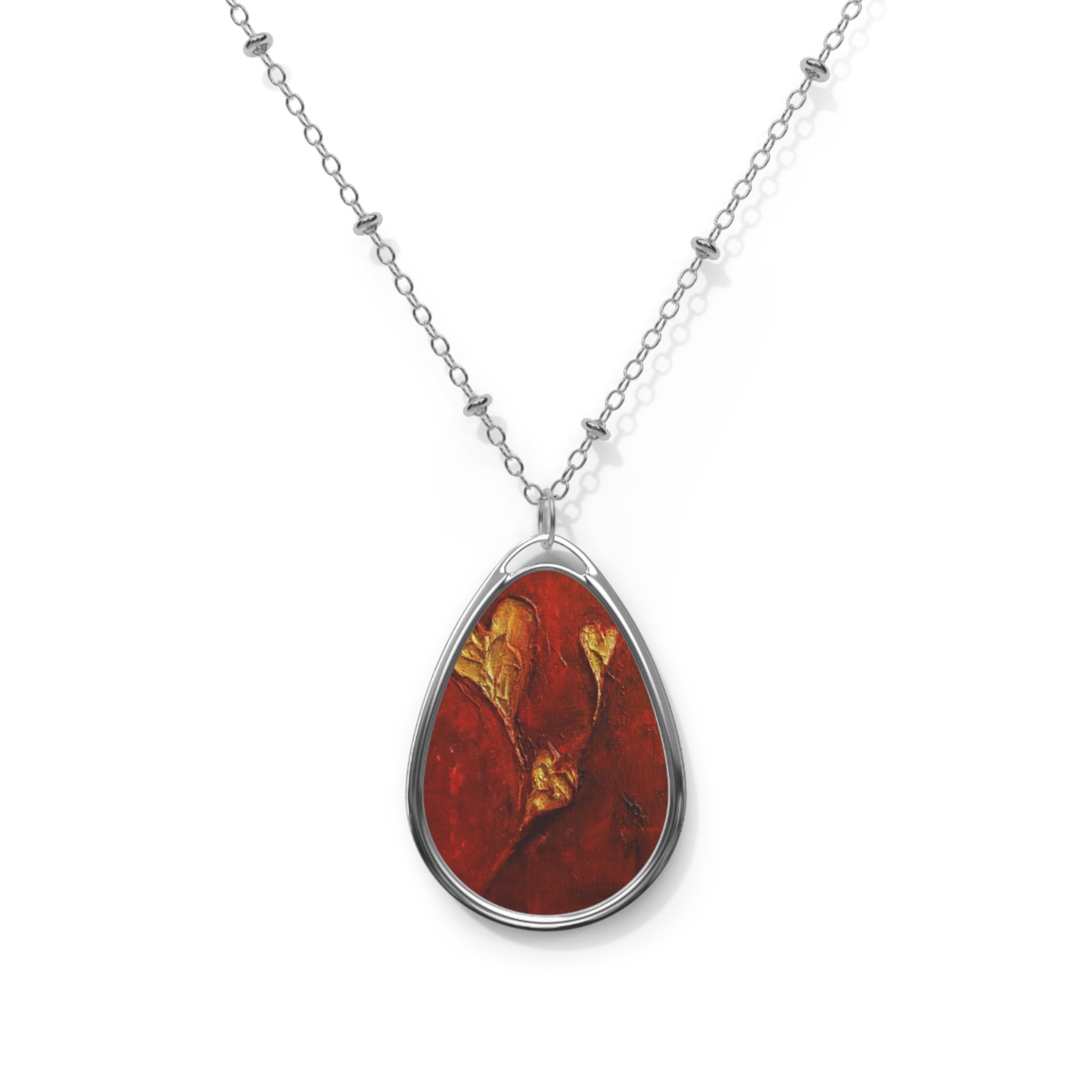 Silver chain necklace with a teardrop-shaped red and gold Scottish Art Jewellery pendant