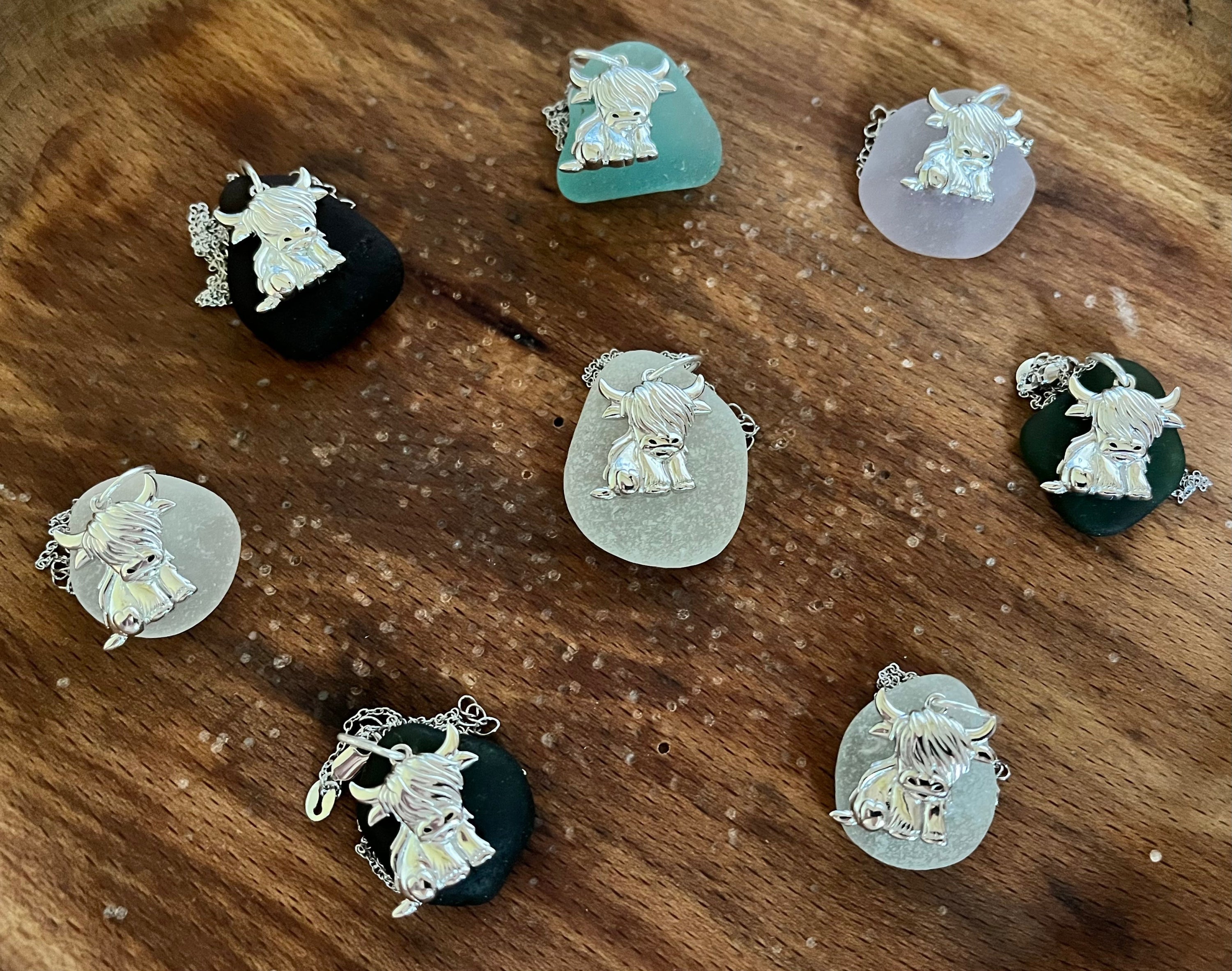Silver Highland Cow Pendants attached to colorful sea glass pieces for jewelry making