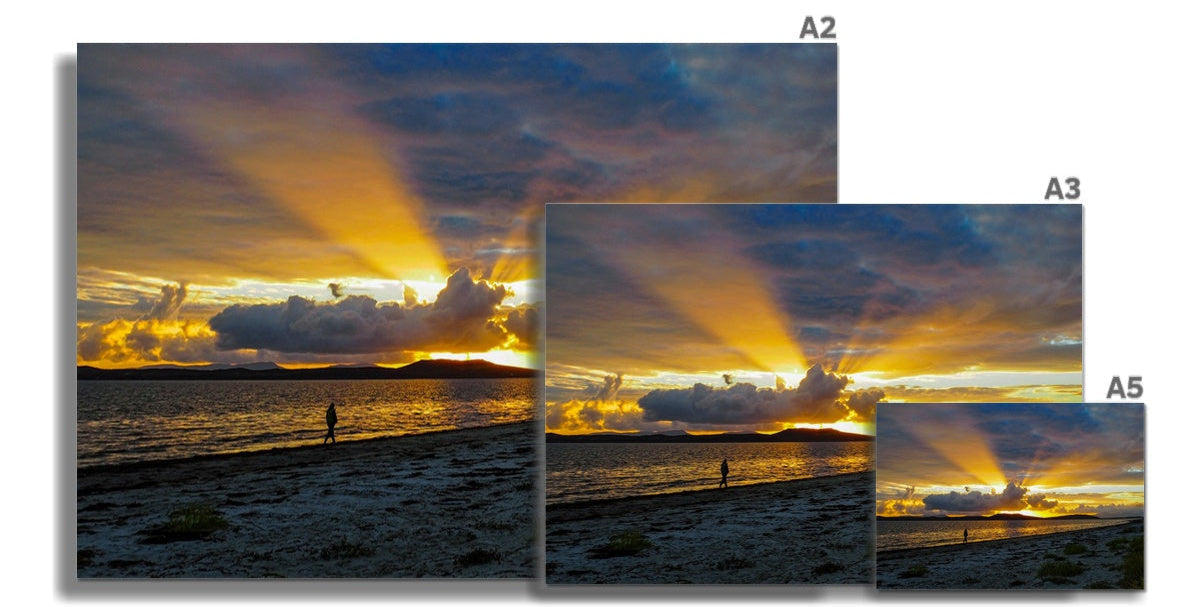 Golden sunbeams over dramatic Jura sunset sky, illuminating shoreline clouds