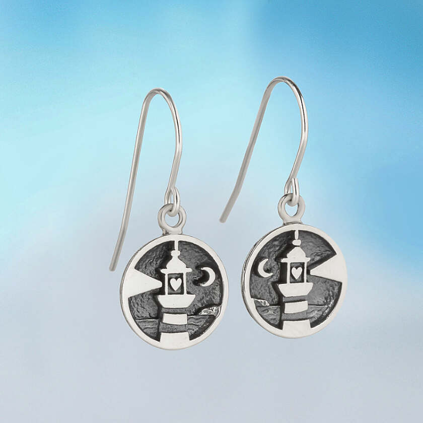 Silver lighthouse earrings featuring circular dangle design with intricate lantern and moon detailing on textured background