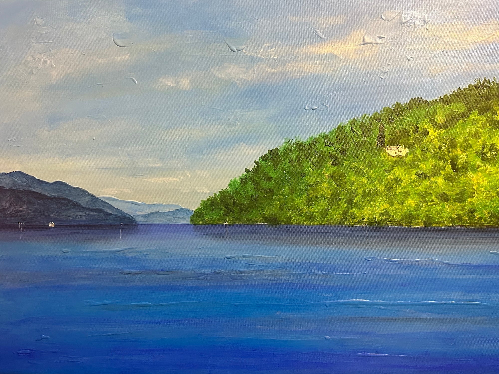 Serene painting of a blue lake with green hills and distant mountains under a partly cloudy sky