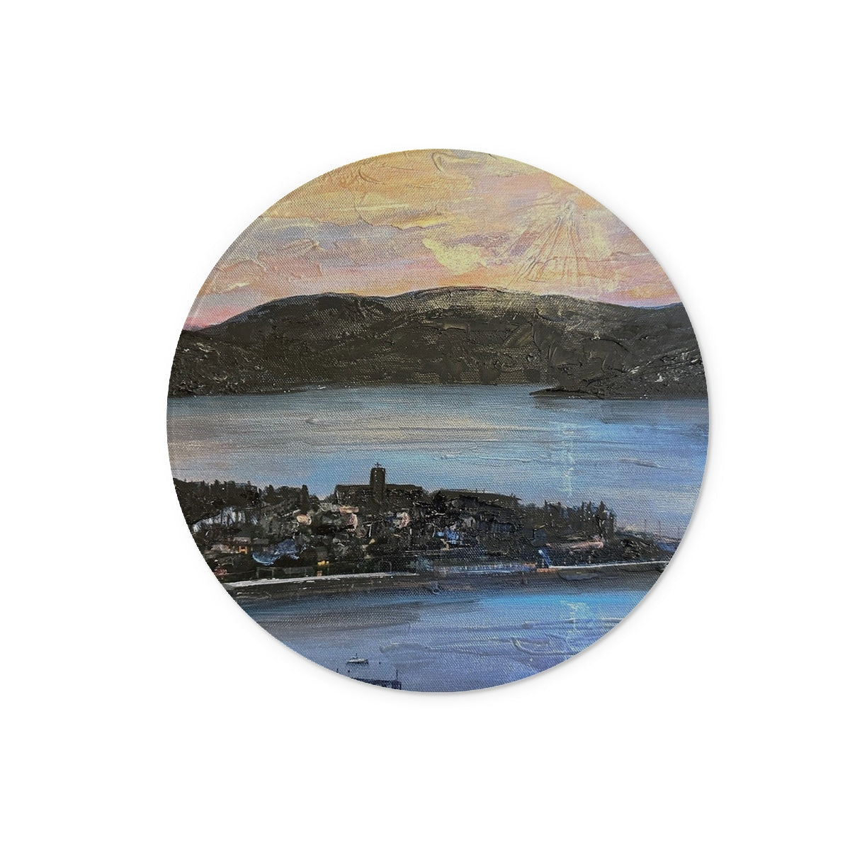 Circular oil painting of a coastal town with church tower, mountains, and water at sunset on From Lyle Hill Glass Chopping Board
