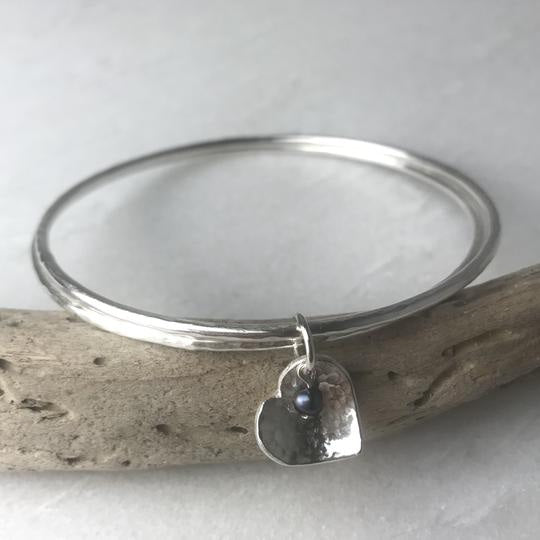 Silver heart pendant with blue bead on Peacock Pearl Heart Double Bangle by Lindsay Mcdowall Jewellery