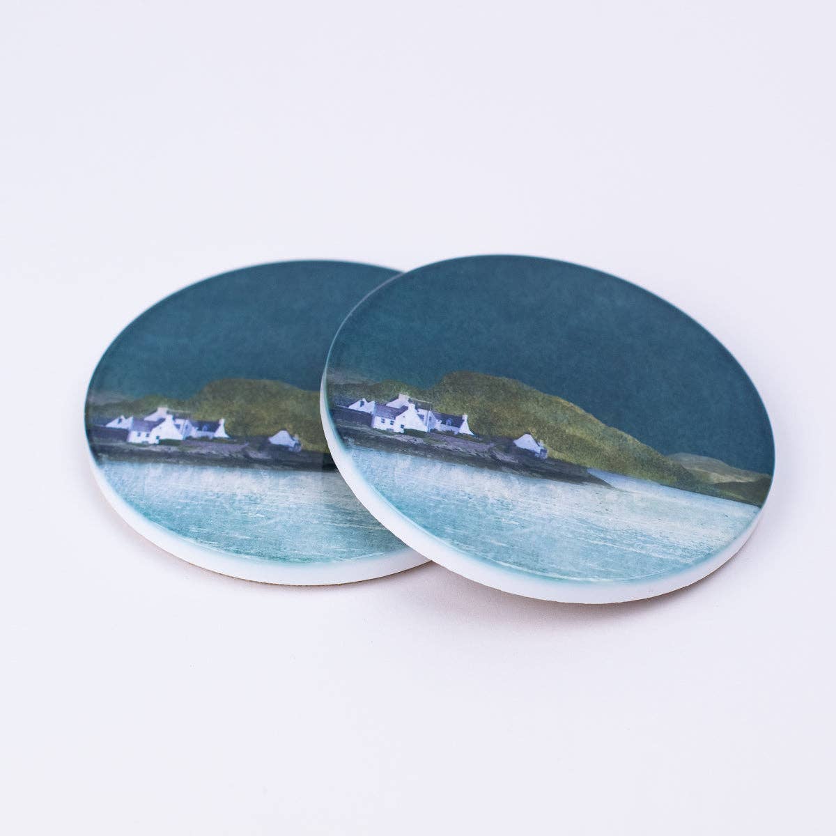 Plockton ceramic coaster gift boxed featuring circular coasters painted with white houses green hills and teal water