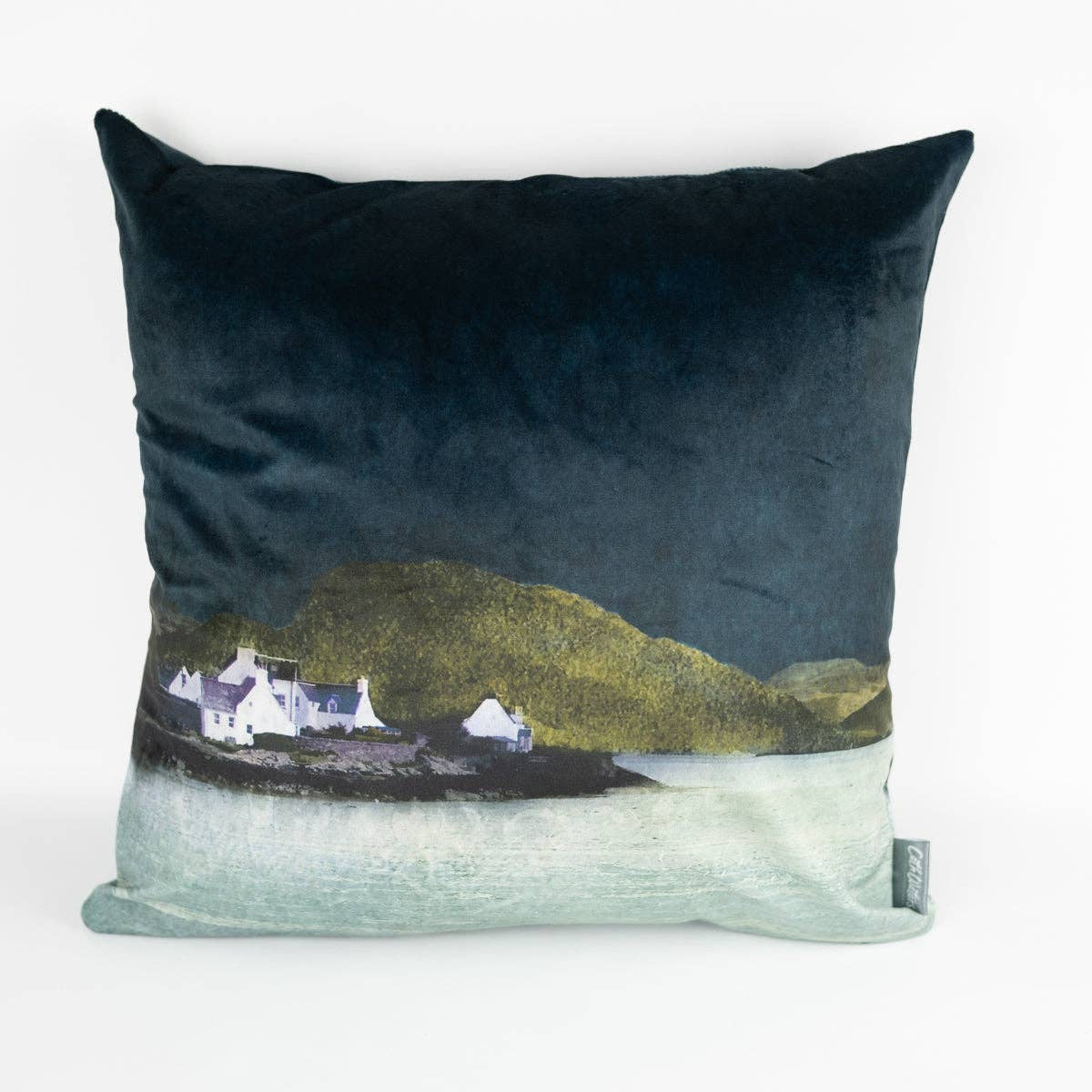 Plockton velvet cushion by Cath Waters: dark teal coastal scene with white houses, green hills, light blue water