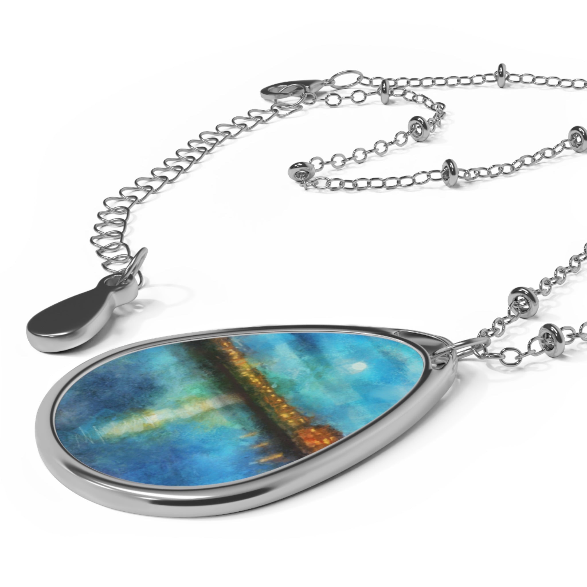 Silver-toned teardrop necklace with blue and gold abstract design from Portobello Moonlight Scottish Art Jewellery