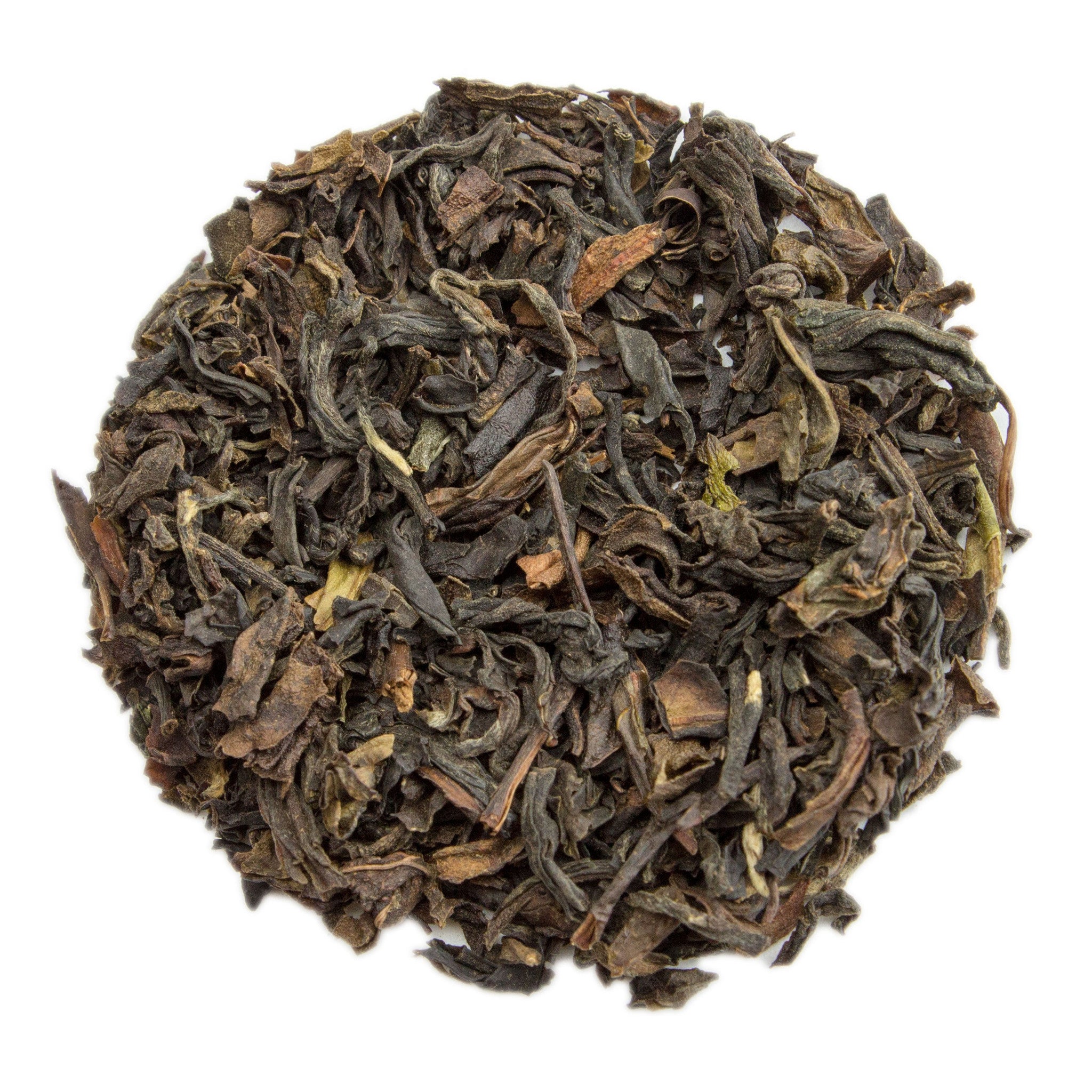 A pile of dark curly black tea leaves with hints of brown and green for russian caravan tea blend