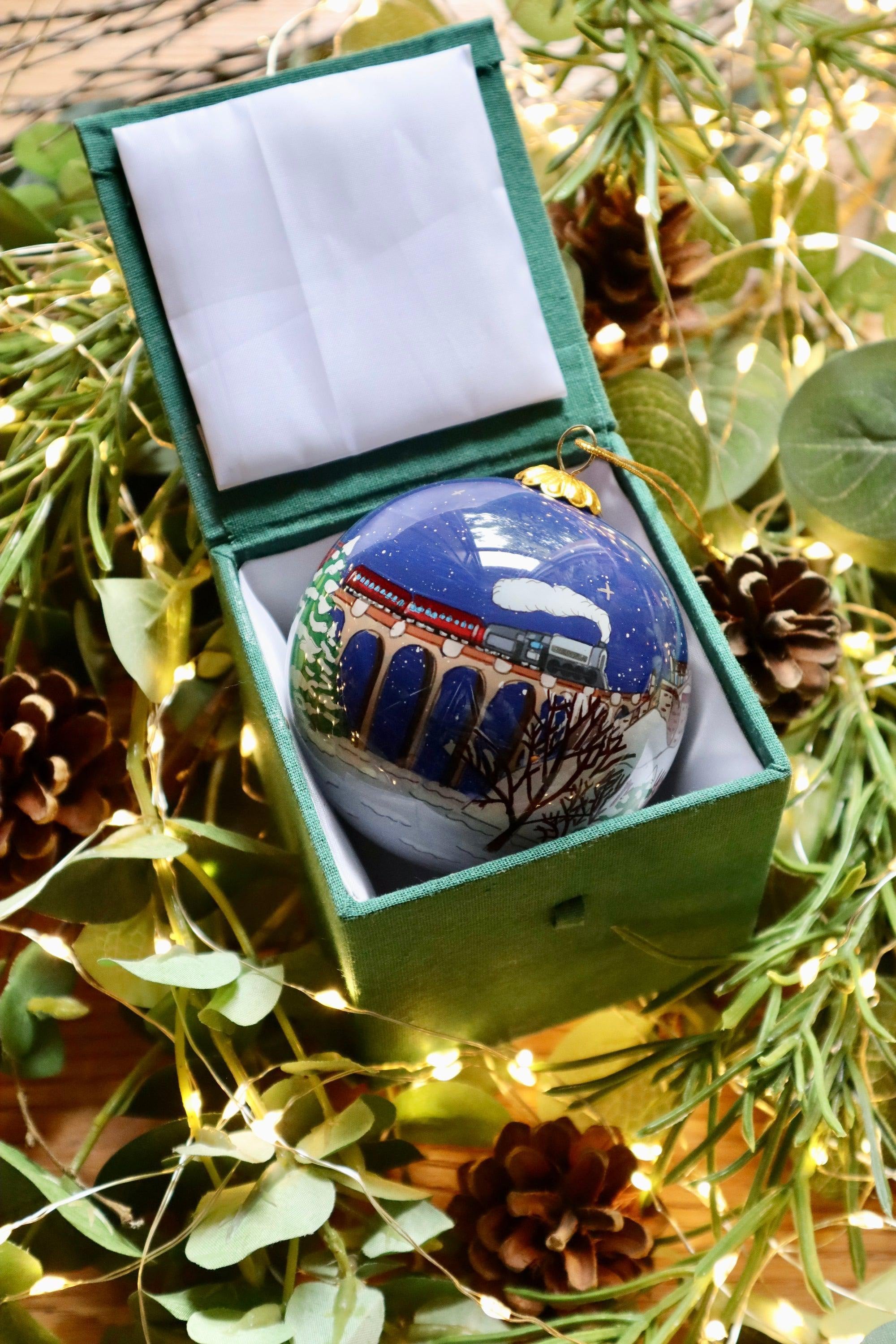 Glossy blue Scottish Christmas bauble with train under snowy bridge