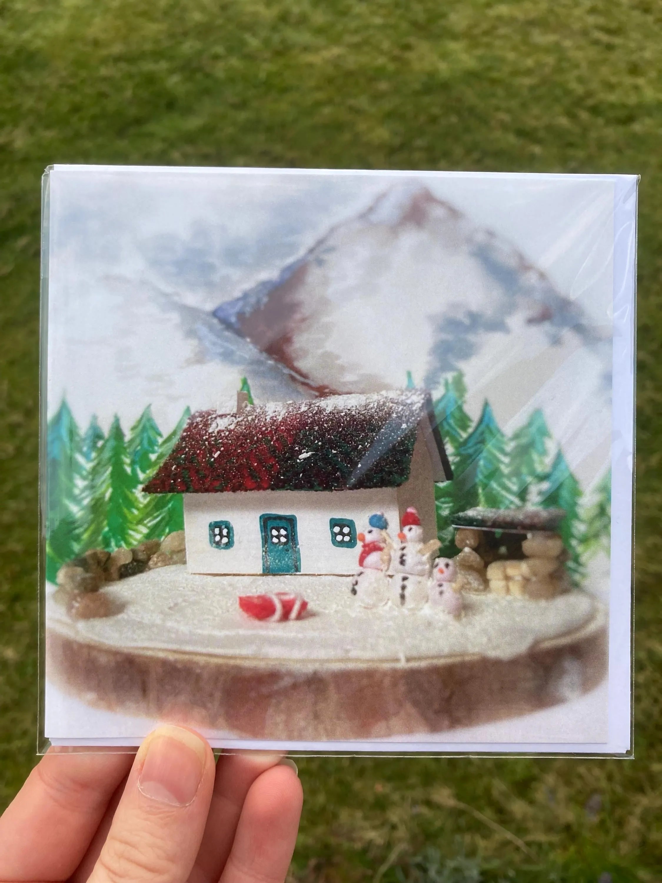 Holiday greeting card featuring a snowy Scottish Highland Bothy scene with snowmen