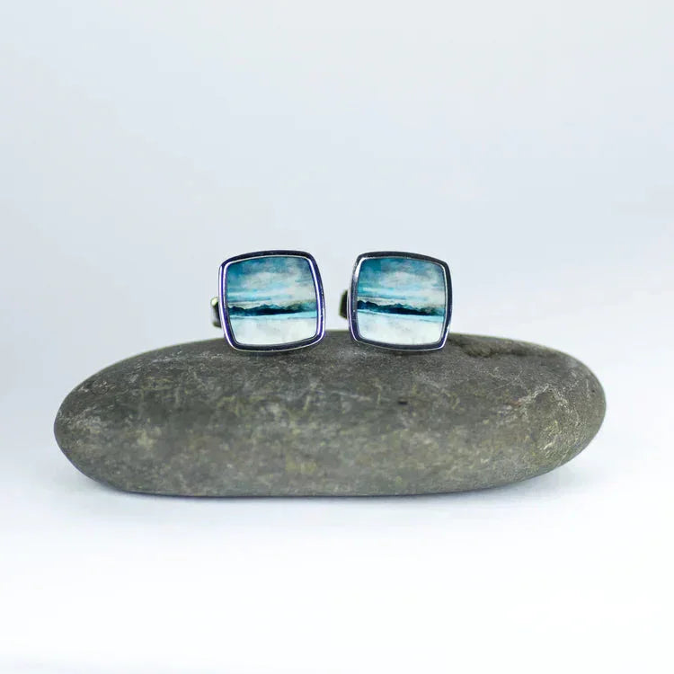 Skye cufflinks by Cath Waters: square silver coastal scene with blue skies and ocean waves
