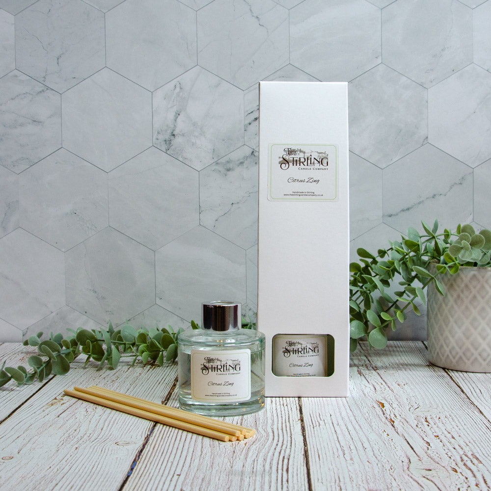 Clear glass reed diffuser bottle with silver cap and white stirling candle company label for citrus zing scent 100ml