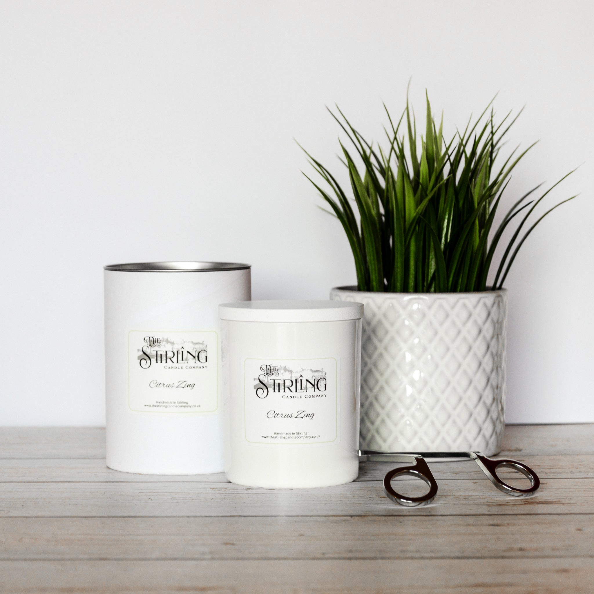Large white cylindrical citrus zing candle container with silver lid and black stirling candle company label