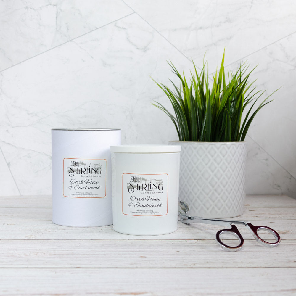 Two white cylindrical dark honey and sandalwood scented candles from stirling candle company large candle set
