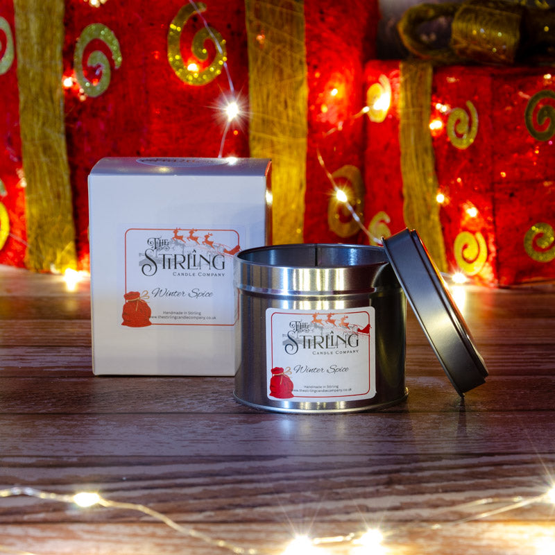 A silver tin winter spice travel candle with cotton wick from stirling candle company featuring festive reindeer design