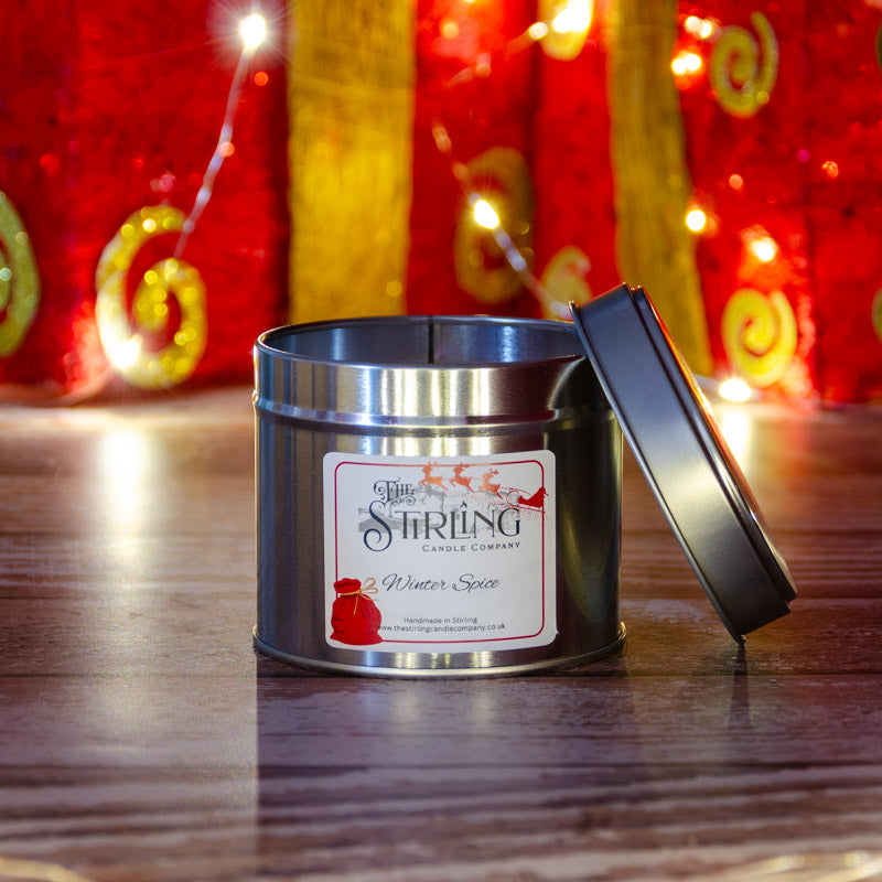 Winter spice travel tin candle by string candle company silver cylindrical tin with cotton wick and festive red sack label