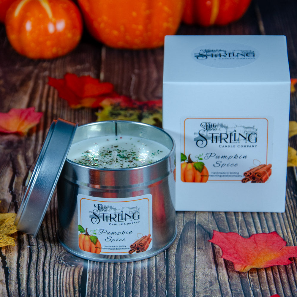 Silver tin travel candle with white wax green spice sprinkles labeled pumpkin spice by stirling candle company cotton wick