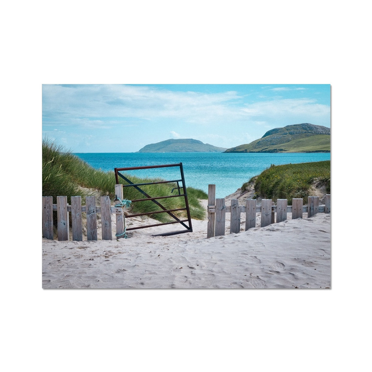 Rustic black metal gate leaning on weathered wooden fence at Vatersay Beach