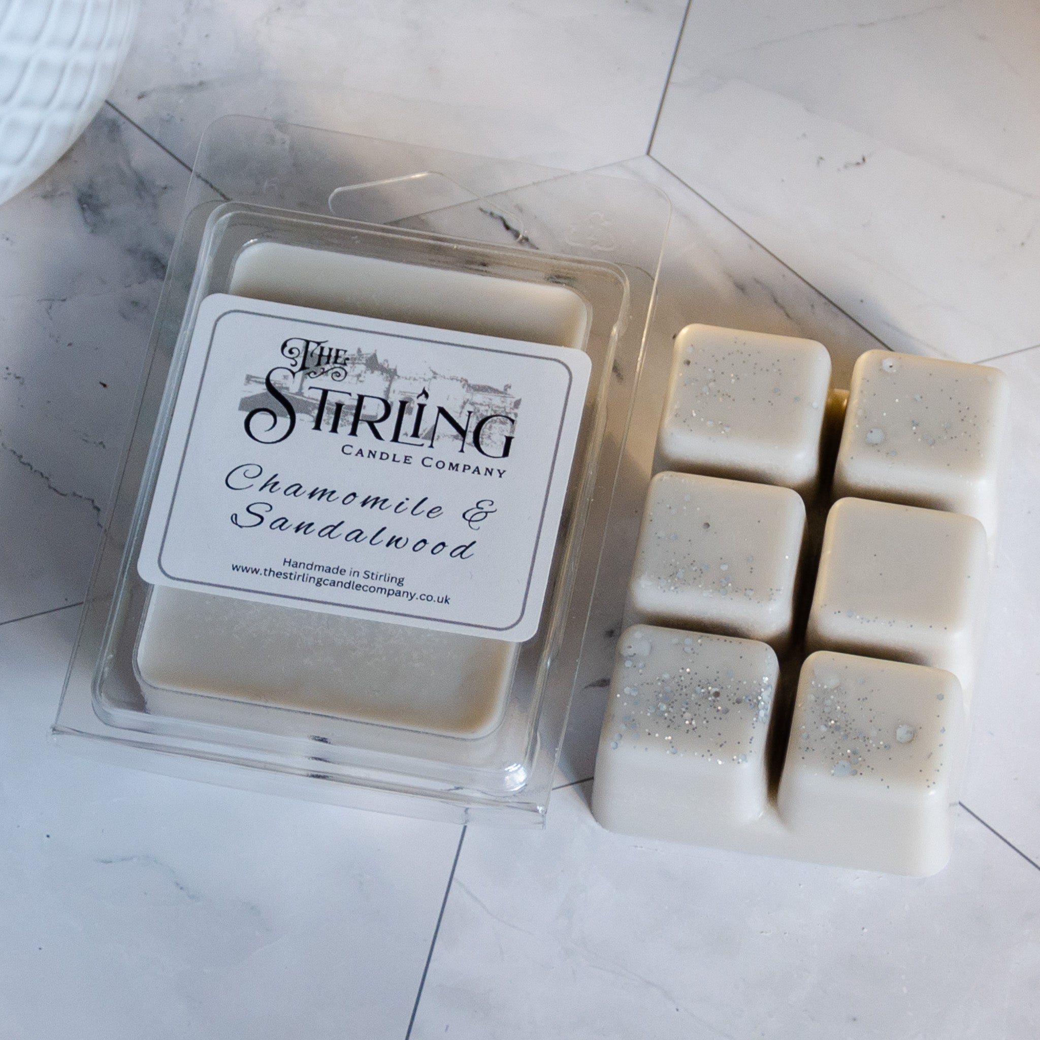 Cream-colored square wax melts with silver glitter in a clear tray from the stirling candle company chamomile and sandalwood scent