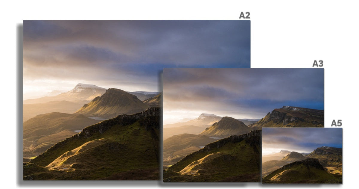 A framed fine art print of a quiraing sunrise landscape with misty sunlit mountains in green and brown hues under a dramatic sky