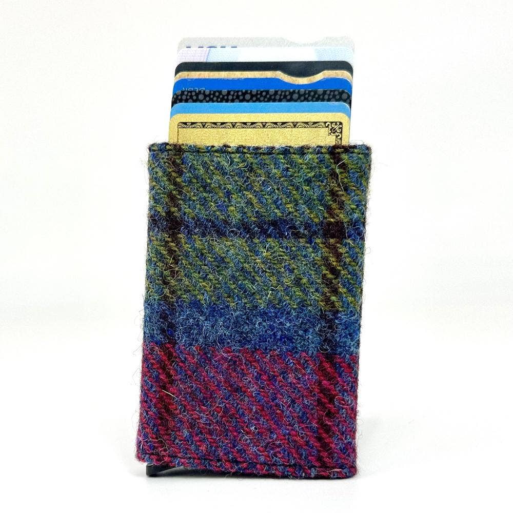 A compact pop up card holder in blue pink check with a multi-colored woolen woven pattern in blue green and purple