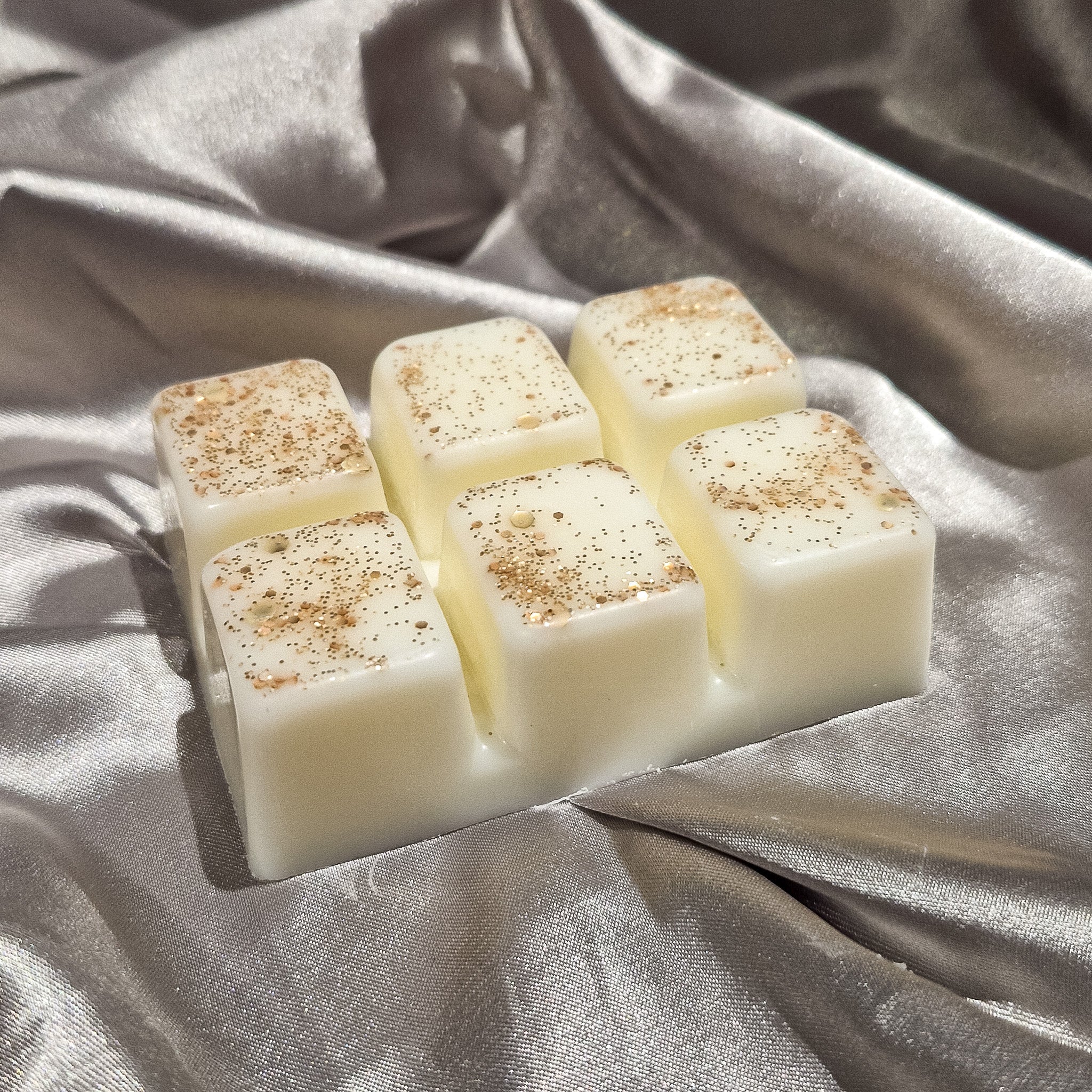 Cream-colored blushing orchid wax melt clamshell blocks with speckled golden-brown finish for home fragrance