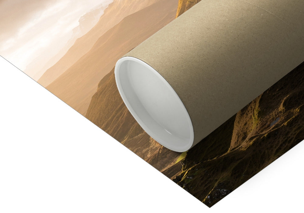 Rolled brown cardboard tube resting on a landscape print, showcasing mountains and soft, warm colors in the background.